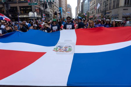 Téléchargez les photos : 41e défilé national de la fête dominicaine 2023. 13 août 2023, New York, New York, États-Unis : Les participants défilent avec un grand drapeau de la République dominicaine au défilé de la fête dominicaine sur la 6e Avenue le 13 août 2023 à New York. - en image libre de droit