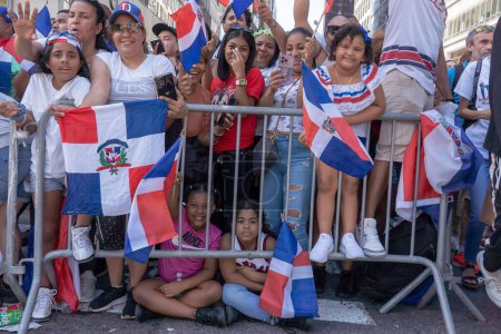 Foto de 41º Desfile Nacional Dominicano 2023. 13 de agosto de 2023, Nueva York, Nueva York, Estados Unidos: Espectadores con banderas de la República Dominicana observan a los manifestantes en el Desfile del Día Dominicano en la Sexta Avenida el 13 de agosto de 2023 en la ciudad de Nueva York. - Imagen libre de derechos