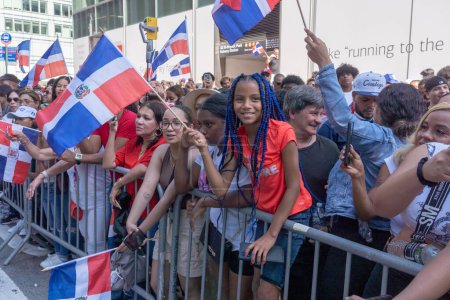Téléchargez les photos : 41e défilé national de la fête dominicaine 2023. 13 août 2023, New York, New York, États-Unis : Des spectateurs avec des drapeaux de la République dominicaine regardent les manifestants au défilé de la fête dominicaine sur la 6e Avenue le 13 août 2023 à New York. - en image libre de droit