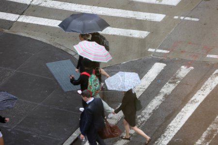 Foto de Nueva York, EE.UU. - 24 de agosto de 2023: Lluvias en la ciudad de Nueva York. El repentino cambio de clima que trae consigo lluvias que obligan a neoyorquinos y turistas a protegerse con sombrillas, ponchos mientras realizan sus negocios diarios. - Imagen libre de derechos