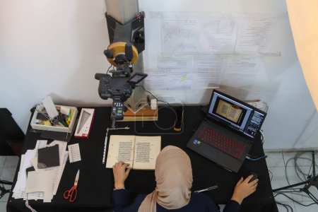 Foto de 06 de septiembre de 2023 - Gaza, Palestina: Investigador palestino que repara y archiva libros y manuscritos antiguos en la ciudad de Gaza. Un equipo de investigadores palestinos de la Fundación Ojos en el Patrimonio trabaja - Imagen libre de derechos