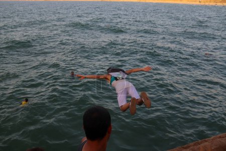Foto de Los palestinos saltan desde lo alto del mar en el puerto de Khan Yunis, Gaza. 8 de septiembre de 2023, Gaza, Palestina: Palestinos viviendo en la concurrida Franja de Gaza, con una intensa ola de calor en verano - Imagen libre de derechos