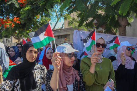 Photo for Palestinian women protest against the Israeli violations against women in Hebron, in front of  "UNESCO" in Gaza - Royalty Free Image