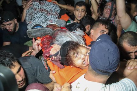 Foto de 13 de septiembre de 2023, Gaza, Palestina: Los palestinos llevan los cuerpos de hombres muertos durante una explosión cerca de la valla fronteriza con Israel. - Imagen libre de derechos