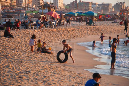 Foto de Los palestinos se divierten en el mar en el puerto de Gaza. 15 de septiembre de 2023 - Gaza, Palestina: Una intensa ola de calor de verano ha sido exacerbada por los cortes de energía causados por el bloqueo israelí. - Imagen libre de derechos