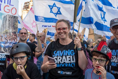 Photo for Israeli Expats and US Jews Protest During Prime Minister Netanyahu's U.N. Visit. September 19, 2023, New York, New York, USA: Protester with two children waves an Israeli flags at a rally outside the Metropolitan Museum of Art - Royalty Free Image