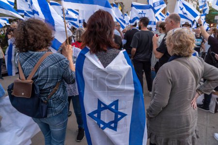 Foto de Expatriados israelíes y judíos estadounidenses protestan durante la visita del Primer Ministro Netanyahu a la ONU. 19 de septiembre de 2023, Nueva York, Nueva York, Estados Unidos: Manifestante envuelto en bandera israelí participa en una manifestación frente al Museo Metropolitano de Arte - Imagen libre de derechos