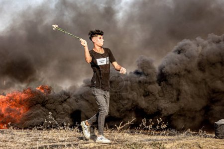 Photo for Palestinian demonstrators burn tires during a protest against repeated attacks on the courtyards of Al-Aqsa Mosque. September 22, 2023. Gaza, Palestine: - Royalty Free Image