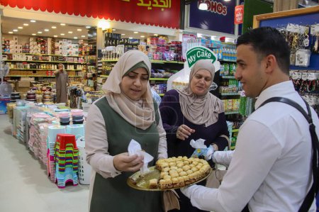 Photo for (INT) Palestinians celebrate the Prophet Muhammad's birthday. September 27, 2023, Gaza, Palestine: Palestinians celebrated  Prophet Muhammad's birthday by distributing sweets to people in the city streets. Additionally, shops and homes were adorned w - Royalty Free Image