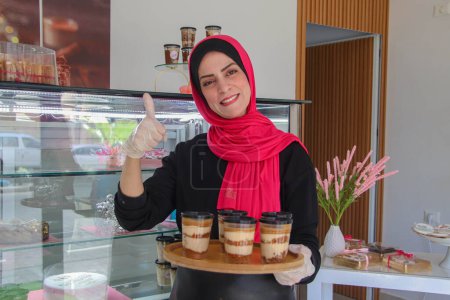Photo for Palestinian Ayat Mutair, 40, who suffers from a hearing disability, makes sweets in her shop. September 28, 2023. Gaza, Palestine - Royalty Free Image