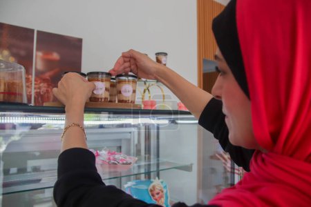 Photo for Palestinian Ayat Mutair, 40, who suffers from a hearing disability, makes sweets in her shop. September 28, 2023. Gaza, Palestine - Royalty Free Image