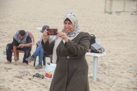 Téléchargez les photos : 2 octobre 2023 - Gaza, Palestine : Des membres palestiniens du Jihad islamique à Gaza se rassemblent autour d'une sculpture sculptée dans le sable à l'occasion du trente-sixième anniversaire de la fondation du Jihad islamique à Gaza. - en image libre de droit
