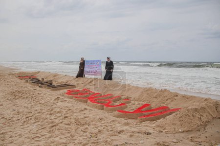Foto de 2 de octubre de 2023 - Gaza, Palestina: miembros palestinos de la Yihad Islámica en la ciudad de Gaza se reúnen alrededor de una escultura tallada en la arena en el trigésimo sexto aniversario de la fundación de la Yihad Islámica en la ciudad de Gaza. - Imagen libre de derechos
