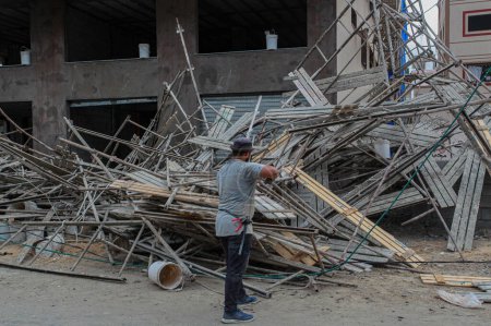 Foto de 02 de octubre de 2023 - Gaza, Palestina: Un miembro de la Defensa Civil palestina inspecciona el sitio del colapso de un bloque de construcción colocado en un edificio en construcción en la ciudad de Gaza. - Imagen libre de derechos
