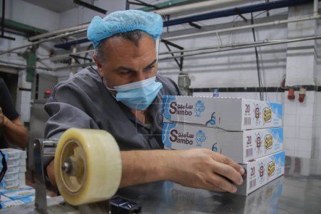 Téléchargez les photos : 4 octobre 2023 - Gaza, Palestine : Travail palestinien dans l'usine Al-Arousa pour produire le bonbon saisonnier et populaire connu dans la ville de Gaza sous le nom de Shatawi. - en image libre de droit