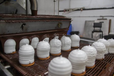 Téléchargez les photos : 4 octobre 2023 - Gaza, Palestine : Des Palestiniens travaillent dans l'usine Al-Arousa pour produire le bonbon saisonnier et populaire connu dans la ville de Gaza sous le nom de Shatawi. - en image libre de droit