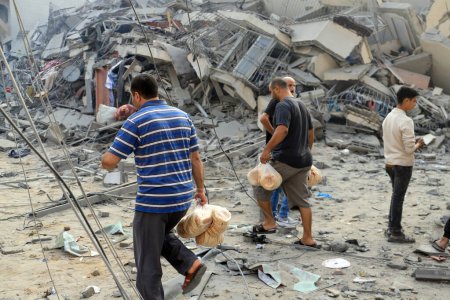 Foto de Los palestinos inspeccionan las ruinas de la Torre Watan, que fue destruida por los ataques aéreos israelíes en la ciudad de Gaza, el 8 de octubre de 2023. Gaza, Palestina: los palestinos inspeccionan las ruinas de la Torre Watan, que fue destruida por los ataques aéreos israelíes en Gaza - Imagen libre de derechos