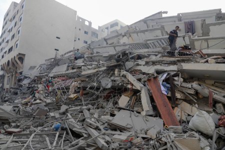 Foto de Los palestinos inspeccionan las ruinas de la Torre Watan, que fue destruida por los ataques aéreos israelíes en la ciudad de Gaza, el 8 de octubre de 2023. Gaza, Palestina: los palestinos inspeccionan las ruinas de la Torre Watan, que fue destruida por los ataques aéreos israelíes en Gaza - Imagen libre de derechos