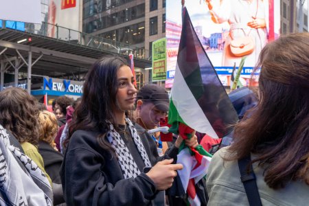Foto de Manifestación y marcha pro-palestina en Times Square de Nueva York mientras Israel declara la guerra a Hamás en el Medio Oriente. 8 de octubre de 2023, Nueva York, Nueva York, Estados Unidos: Una mujer sostiene una bandera palestina en un mitin en apoyo del grupo militante Hamas - Imagen libre de derechos