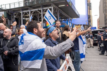 Foto de Manifestación y marcha pro-palestina en Times Square de Nueva York mientras Israel declara la guerra a Hamás en el Medio Oriente. 8 de octubre de 2023, Nueva York, Nueva York, Estados Unidos: Oficiales de la policía de Nueva York separan a los contramanifestantes con banderas israelíes en una manifestación - Imagen libre de derechos