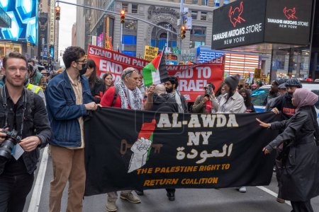 Photo for Pro-Palestinian Rally and March Held In New York's Times Square As Israel Declares War On Hamas In The Middle East. October 8, 2023, New York, New York, USA: Demonstrators holding banner, signs and flags march in support of militant group - Royalty Free Image