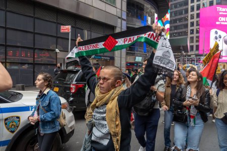 Téléchargez les photos : Rassemblement pro-palestinien et mars à Times Square à New York alors qu'Israël déclare la guerre au Hamas au Moyen-Orient. 8 octobre 2023, New York, New York, USA : Des manifestants tenant banderole, pancartes et drapeaux défilent pour soutenir un groupe militant - en image libre de droit