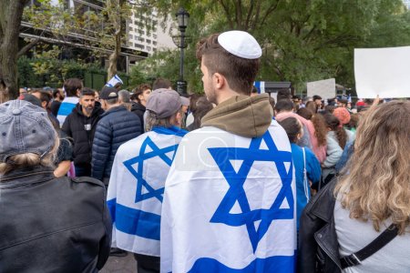 Photo for Pro-Israel Rally Held At New York City After Hamas Attack. October 8, 2023, New York, New York, USA: Participants drape with Israeli flags at a pro-Israel rally outside the U.N. while the Security Council meets to discuss the conflict - Royalty Free Image