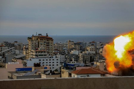 Photo for (INT) Smoke and flames billow after Israeli forces hit a high-rise tower in Gaza City. October10, 2023, Gaza, Palestine: Palestinian militants have started a "war" against Israel, infiltrating by air, sea and land from the blockaded Gaza Strip - Royalty Free Image
