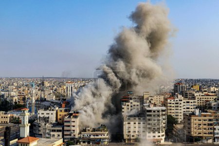 Photo for (INT) Smoke and flames billow after Israeli forces hit a high-rise tower in Gaza City. October10, 2023, Gaza, Palestine: Palestinian militants have started a "war" against Israel, infiltrating by air, sea and land from the blockaded Gaza Strip - Royalty Free Image