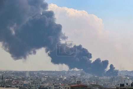 Photo for Smoke and flames billow after Israeli forces hit a high-rise tower in Gaza City. October11, 2023, Gaza, Palestine: Palestinian militants have started a "war" against Israel, infiltrating by air, sea and land from the blockaded Gaza Strip - Royalty Free Image
