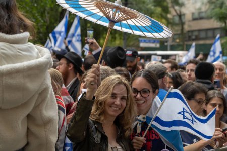 Téléchargez les photos : Rassemblement et veillée à New York pour se tenir aux côtés d'Israël après l'attaque du Hamas. 10 octobre 2023, New York, New York, USA : les femmes tiennent un parasol aux couleurs du drapeau israélien et un drapeau israélien dans un New York Stands With Israel - en image libre de droit