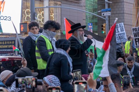 Foto de Activistas pro-palestinos se reúnen para un día de acción. 13 de octubre de 2023, Nueva York, Nueva York, Estados Unidos: Un miembro de Neturei Karta un judío ortodoxo antisionista Cult sostiene una bandera palestina durante una protesta palestina por el Día de Acción en Times Square - Imagen libre de derechos