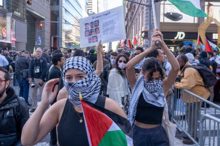 Foto de Activistas pro-palestinos se reúnen para un día de acción. 13 de octubre de 2023, Nueva York, Nueva York, Estados Unidos: Manifestantes pro-palestinos sostienen banderas durante una protesta palestina de un Día de Acción en Times Square el 13 de octubre de 2023 en Nueva York - Imagen libre de derechos
