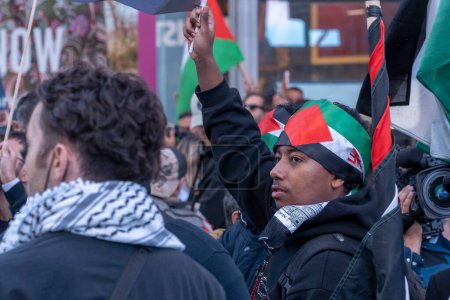 Foto de Activistas pro-palestinos se reúnen para un día de acción. 13 de octubre de 2023, Nueva York, Nueva York, Estados Unidos: Manifestante pro-palestino con banderas palestinas visto durante una protesta palestina por el Día de Acción en Times Square el 13 de octubre de 2023 - Imagen libre de derechos