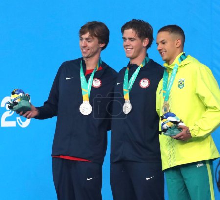 Photo for SANTIAGO, CHILE - 10/23/2023: Medal ceremony in the men's 100M Freestyle won by the Brazilian GUILHERME SANTOS (Gold) and the Americans BROOKS CURRY and JONATHAN KULOW (Silver) at the Aquatic Center of the National Stadium, Santiago, Chile - Royalty Free Image