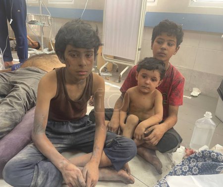 Foto de GAZA (PALESTINA) - 23 / 10 / 2023: Palestinos heridos llevados al Hospital Médico Al-Shifa de Gaza tras violentos y fuertes ataques de aviones de combate israelíes contra sus hogares - Imagen libre de derechos