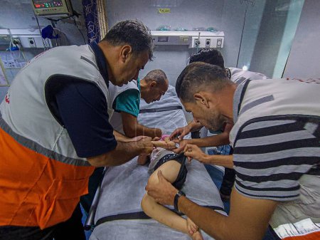 Foto de GAZA (PALESTINA), 30 / 10 / 2023 - Equipos médicos de la Media Luna Roja Palestina rescatan a niños de los escombros mientras atacan un edificio al sur de la ciudad de Gaza, en la provincia de Khan Yunis - Imagen libre de derechos