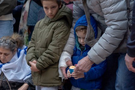 Photo for Candlelight Vigil for Victims of Terrorist Attacks in Israel. November 1, 2023, New York, New York, USA: A man helps a child light a candle at a Candlelight Vigil for the 1400 victims of the October 7 Hamas terrorist attacks in Israel - Royalty Free Image