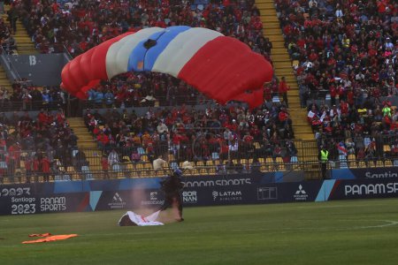 Photo for Vina del Mar, Chile - 04/11/2023: Match of the Brazil team against Chile, in the final of the Pan American Games, at the Sausalito Stadium in Vina del Mar, November 4, 2023. Man on parachute with the colors of Chile national flag - Royalty Free Image