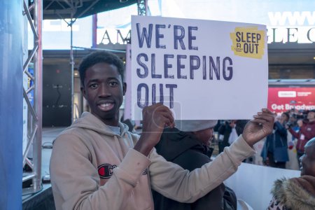 Téléchargez les photos : Covenant House organise "Sleep Out" pour aider à mettre fin à l'itinérance des jeunes. 16 novembre 2023, New York, New York, USA : Participant avec une pancarte assiste à un "Sleep Out" de Covenant House pour sensibiliser les jeunes sans-abri à Times Square - en image libre de droit