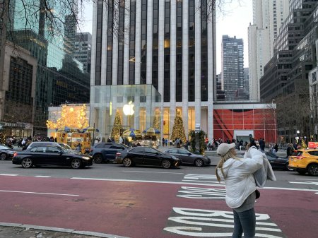 Téléchargez les photos : New Yorkers Crowd Apple Store pour faire du shopping le jour de Noël. 25 décembre 2023, New York, États-Unis : Les New-Yorkais et les touristes profitent des vacances de Noël pour faire du shopping à l'Apple Store de la 5e Avenue, surpeuplant tout l'espace. - en image libre de droit