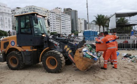 Foto de RIO DE JANEIRO (RJ), BRASIL 01 / 01 / 2024 - Los empleados de COMLURB trabajan intensamente esta mañana (01) para eliminar toneladas de basura el primer día del año después de la fiesta de Nochevieja en la playa de Copacabana - Imagen libre de derechos