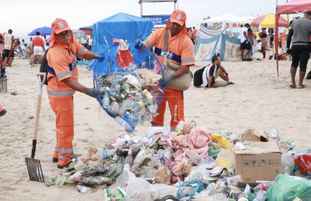Foto de RIO DE JANEIRO (RJ), BRASIL 01 / 01 / 2024 - Los empleados de COMLURB trabajan intensamente esta mañana (01) para eliminar toneladas de basura el primer día del año después de la fiesta de Nochevieja en la playa de Copacabana - Imagen libre de derechos