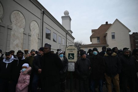 Foto de Los dolientes rinden sus respetos en el Janazah (funeral) del Imam Hassan Sharif en el NIA Masjid and Community Center en Newark, Nueva Jersey. 6 de enero de 2024, Newark, Nueva Jersey, Estados Unidos: Los dolientes se abrazaron, oraron y adoraron fuera del edificio - Imagen libre de derechos