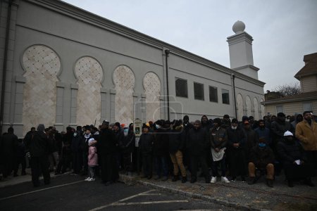 Photo for Mourners pay their respects at the Janazah (funeral) of Imam Hassan Sharif at NIA Masjid and Community Center in Newark, New Jersey. January 6, 2024, Newark, New Jersey, USA: Mourners hugged, prayed and worshipped outside of the building - Royalty Free Image
