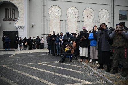 Foto de Los dolientes rinden sus respetos en el Janazah (funeral) del Imam Hassan Sharif en el NIA Masjid and Community Center en Newark, Nueva Jersey. 6 de enero de 2024, Newark, Nueva Jersey, Estados Unidos: Los dolientes se abrazaron, oraron y adoraron fuera del edificio - Imagen libre de derechos