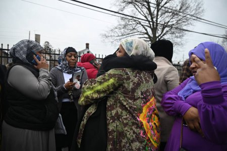 Foto de Familiares y amigos asisten al Janazah (funeral) del Imam Hassan Sharif en el NIA Masjid and Community Center en Newark, Nueva Jersey. 6 de enero de 2024, Newark, Nueva Jersey, Estados Unidos: Los dolientes se abrazaron, oraron y adoraron fuera del edificio - Imagen libre de derechos