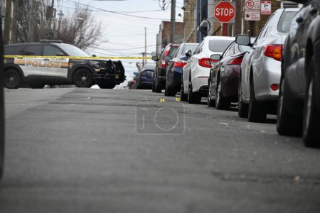Foto de El tiroteo deja un vehículo golpeado por disparos y varios casquillos de bala en la calle en Paterson, Nueva Jersey. 11 de febrero de 2024, Paterson, Nueva Jersey, EE. UU.: Vehículo golpeado por disparos y varios casquillos de bala en la avenida 12 en Paterson - Imagen libre de derechos