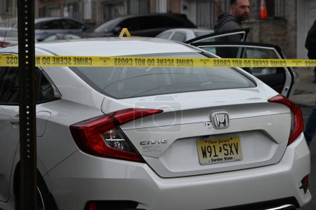 Photo for Shooting leaves a vehicle struck by gunfire and several shell casings in the street in Paterson, New Jersey. February 11, 2024, Paterson, New Jersey, USA: Vehicle struck by gunfire and several shell casings on 12th Avenue in Paterson - Royalty Free Image