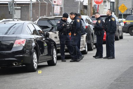 Photo for Shooting leaves a vehicle struck by gunfire and several shell casings in the street in Paterson, New Jersey. February 11, 2024, Paterson, New Jersey, USA: Vehicle struck by gunfire and several shell casings on 12th Avenue in Paterson - Royalty Free Image